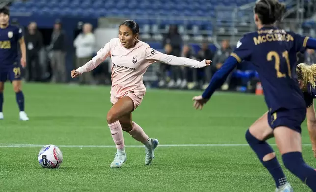 Angel City FC forward Alyssa Thompson moves the ball against Seattle Reign defender Phoebe McClernon (21) during the second half of an NWSL soccer match Friday, Oct. 4, 2024, in Seattle. Angel City won 1-0. (AP Photo/Lindsey Wasson)