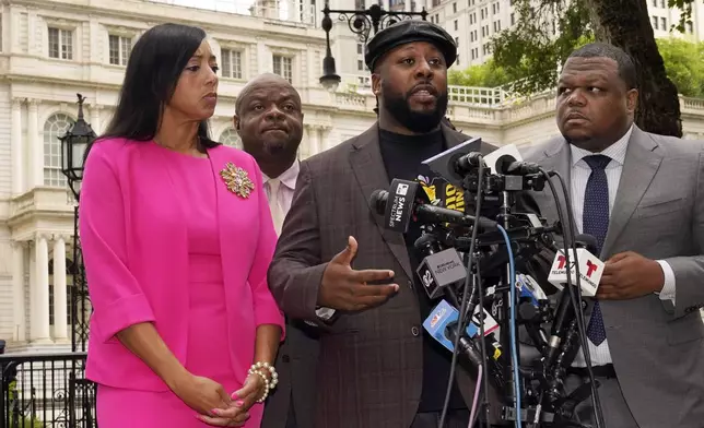 Shamel Kelly, center, flanked by his attorneys Bernarda Villalona, left, and Harry Daniels, right, speaks during a news conference in New York's City Hall Park, Tuesday, Oct. 1, 2024. (AP Photo/Richard Drew)