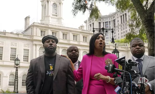 Shamel Kelly, left, with his attorneys Bernarda Villalona, center, and Harry Daniels, right, hold a news conference in New York's City Hall Park, Tuesday, Oct. 1, 2024. (AP Photo/Richard Drew)