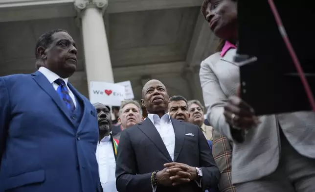 New York City Mayor Eric Adams is surrounded by faith leaders and other supporters during a rally and prayer vigil on the steps of City Hall in New York, Tuesday, Oct. 1, 2024. (AP Photo/Seth Wenig)