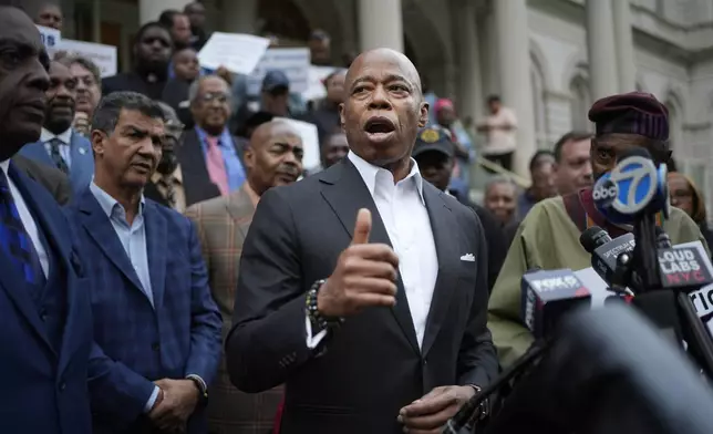 New York City Mayor Eric Adams speaks while surrounded by faith leaders and other supporters during a rally and prayer vigil on the steps of City Hall in New York, Tuesday, Oct. 1, 2024. (AP Photo/Seth Wenig)