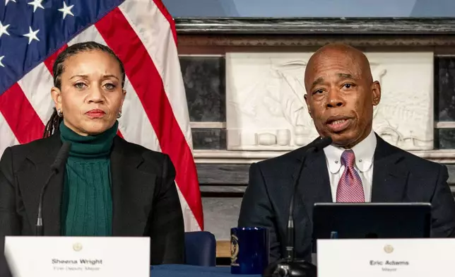 FILE - Mayor Eric Adams, right, is flanked by deputy mayor Sheena Wright, left, during a press conference at City Hall in New York, Dec. 12, 2023. (AP Photo/Peter K. Afriyie, File)