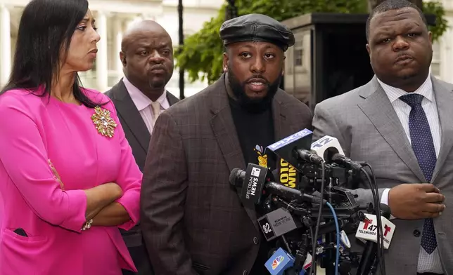 Shamel Kelly, center, flanked by his attorneys Bernarda Villalona, left, and Harry Daniels, right, speaks during a news conference in New York's City Hall Park, Tuesday, Oct. 1, 2024. (AP Photo/Richard Drew)