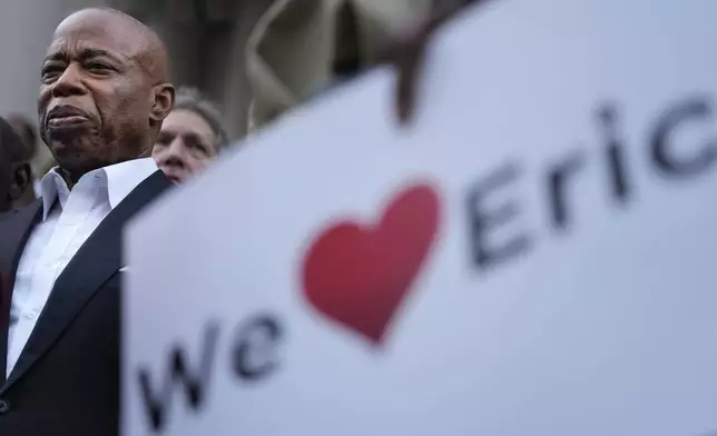 New York City Mayor Eric Adams, left, is surrounded by faith leaders and other supporters during a rally and prayer vigil on the steps of City Hall in New York, Tuesday, Oct. 1, 2024. (AP Photo/Seth Wenig)