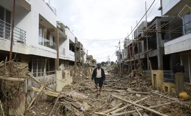 A man walks on a street strewn with debris in Kathmandu, Nepal, Monday, Sept. 30, 2024 in the aftermath of a flood caused by heavy rains. (AP Photo/Gopen Rai)