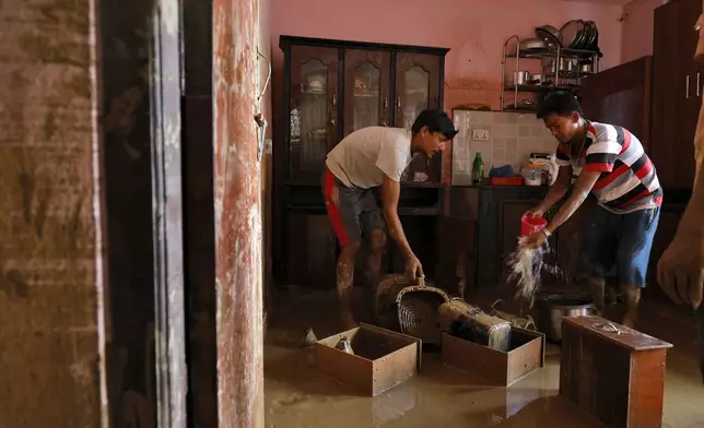 Residents clean their water-logged kitchen in Kathmandu, Nepal, Monday, Sept. 30, 2024 after a flood caused by heavy rains. (AP Photo/Gopen Rai)