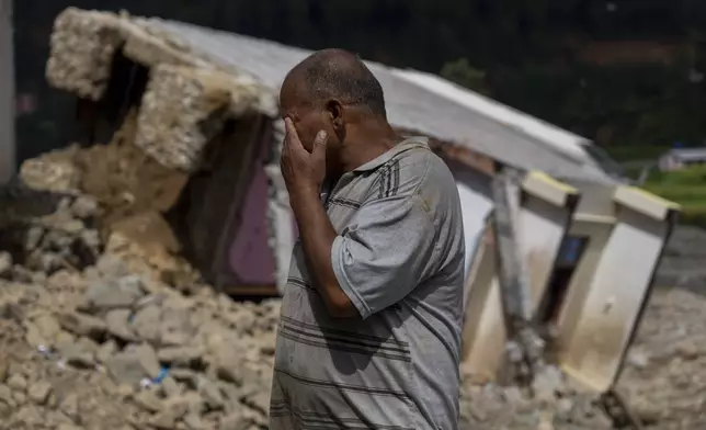 Bishworaj Khadka, 52, weeps in front of his house which had collapsed due to flooding in the Nakhu river caused by heavy rains in Lalitpur, Nepal, on Tuesday, Oct. 1, 2024. (AP Photo/Niranjan Shrestha)