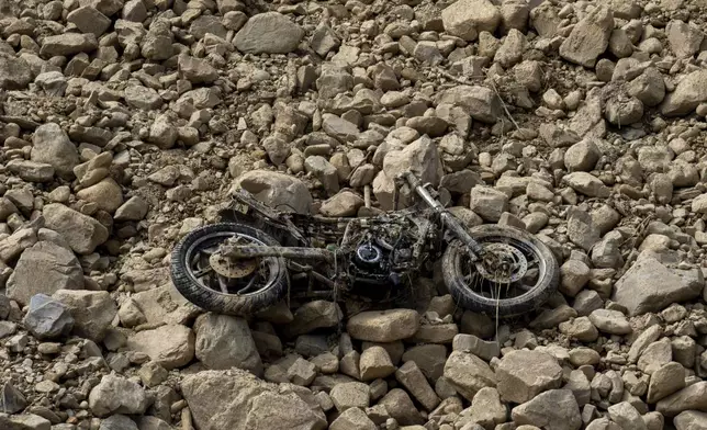 A motorbike lies on the bed of the Nakhu river washed away in the floods caused by heavy rains in Lalitpur, Nepal, on Tuesday, Oct. 1, 2024. (AP Photo/Niranjan Shrestha)