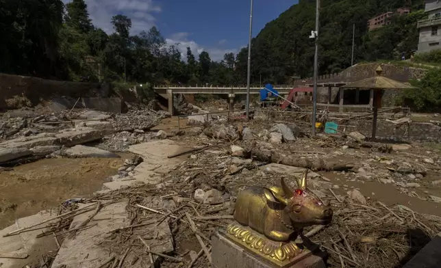 An idol of the Nandi, the vehicle of Hindu god Shiva, lies at the Tika Bhairabh Temple premises damaged in the floods caused by heavy rains in Lalitpur, Nepal, on Tuesday, Oct. 1, 2024. (AP Photo/Niranjan Shrestha)