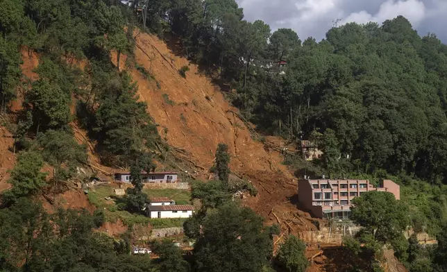 Mud engulfs a mountainside where a building in the Anandabaan hospital premises was damaged in a landslide caused by heavy rains in Lalitpur, Nepal, on Tuesday, Oct. 1, 2024. (AP Photo/Niranjan Shrestha)