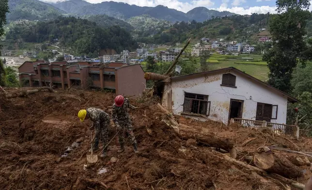 Rescuers search for the body of a missing doctor after a landslide damaged a house in the Anandaban hospital, in Lalitpur, Nepal, Tuesday, Oct. 1, 2024. (AP Photo/Niranjan Shrestha)