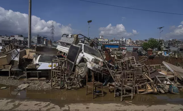 Vehicles and furniture damaged in the floods caused by heavy rains are kept on the side of a road, in Kathmandu, Nepal, Tuesday, Oct. 1, 2024. (AP Photo/Niranjan Shrestha)