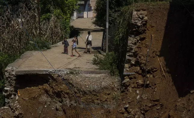 Children play near a house damaged in the floods caused by heavy rains in Lalitpur, Nepal, on Tuesday, Oct. 1, 2024. (AP Photo/Niranjan Shrestha)