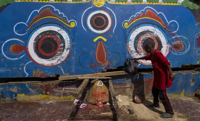 A man stands in front of mural at the Tika Bhairabh Temple premises damaged in the floods caused by heavy rains in Lalitpur, Nepal, on Tuesday, Oct. 1, 2024. (AP Photo/Niranjan Shrestha)