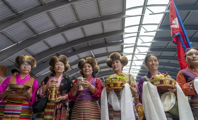 Friends and family of Nepalese mountaineers, including Nima Rinji Sherpa, the youngest person to scale all the world’s 14 highest peaks, gather at Tribhuvan International Airport in Kathmandu, Nepal, Monday, Oct. 14, 2024. (AP Photo/Niranjan Shrestha)