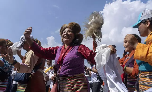 Friends and family of Nepalese mountaineers, including Nima Rinji Sherpa, the youngest person to scale all the world’s 14 highest peaks, dance upon their arrival at Tribhuvan International Airport in Kathmandu, Nepal, Monday, Oct. 14, 2024. (AP Photo/Niranjan Shrestha)