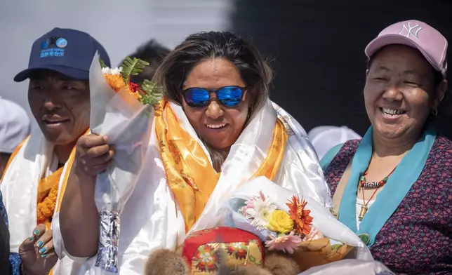 Family members of Dawa Yangzum Sherpa, the first Nepalese woman to scale the world's 14 highest peaks, welcome her upon her arrival at Tribhuvan International Airport in Kathmandu, Nepal, Monday, Oct. 14, 2024. (AP Photo/Niranjan Shrestha)