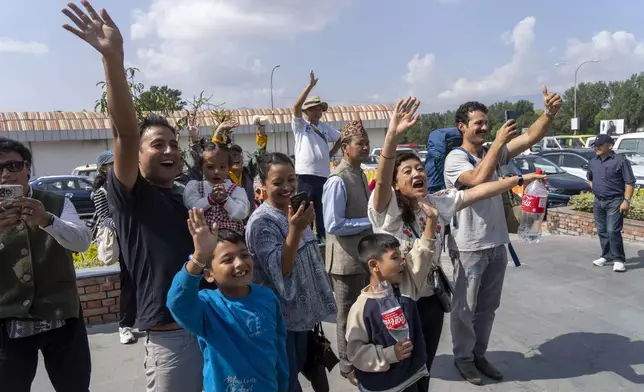 Friends and family of Nepalese mountaineers, including Nima Rinji Sherpa, the youngest person to scale all the world’s 14 highest peaks, gather at Tribhuvan International Airport in Kathmandu, Nepal, Monday, Oct. 14, 2024. (AP Photo/Niranjan Shrestha)