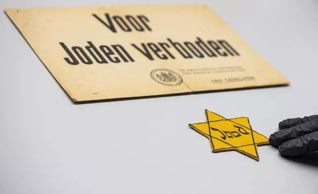 One of the yellow stars Jews were ordered to wear in the occupied Netherlands is displayed next to a sign reading "Forbidden For Jews" at the Anne Frank House in Amsterdam, Netherlands, Friday, Oct. 4, 2024. (AP Photo/Peter Dejong)