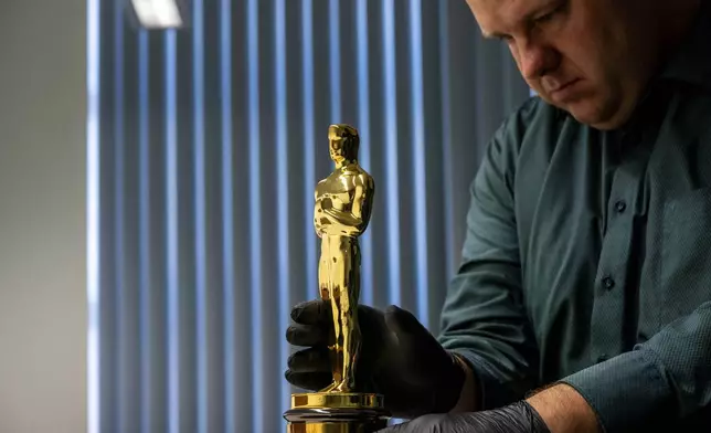 The Best Supporting Actress Oscar won by Shelley Winters for her role in George Stevens' 1959 film, "The Diary of Anne Frank." is displayed by Remco van Doren, manager of the Anne Frank House collection in Amsterdam, Netherlands, Friday, Oct. 4, 2024. (AP Photo/Peter Dejong)