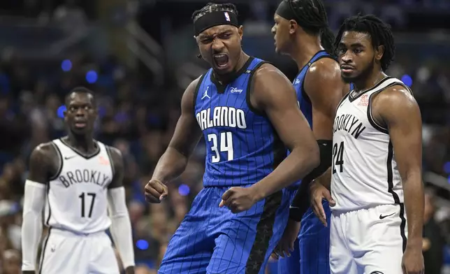 Orlando Magic center Wendell Carter Jr. (34) reacts after scoring as Brooklyn Nets guard Dennis Schroder (17) and guard Cam Thomas (24) look on during the second half of an NBA basketball game, Friday, Oct. 25, 2024, in Orlando, Fla. (AP Photo/Phelan M. Ebenhack)