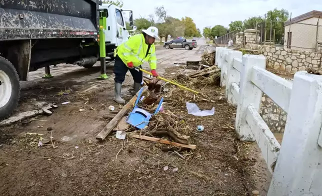 In this image taken from video, a man removes debris from severe flooding in Roswell, N.M., Sunday, Oct. 20, 2024. (Juliana Halvorson via AP)