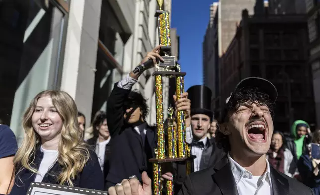 The trophy for the Timothee Chalamet lookalike contest is paraded through the street as the contest organizers move the event to a new location near Washington Square Park, Sunday, Oct. 27, 2024, in New York. (AP Photo/Stefan Jeremiah)