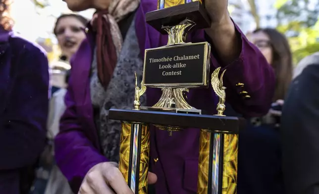 Miles Mitchell, 21, winner of the Timothee Chalamet lookalike contest, holds his trophy near Washington Square Park, Sunday, Oct. 27, 2024, in New York. (AP Photo/Stefan Jeremiah)