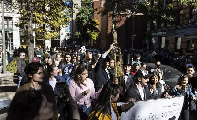 The trophy for the Timothee Chalamet lookalike contest is paraded through the street as the contest organizers move the event to a new location near Washington Square Park, Sunday, Oct. 27, 2024, in New York. (AP Photo/Stefan Jeremiah)