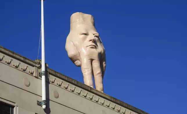 A 16-foot- ( almost 5 meters ) tall hand sculpture named Quasi stands perched on its fingertips atop the roof of an art gallery in Wellington, New Zealand, Wednesday, Oct. 30, 2024. (AP photo/Charlotte Graham-McLay)