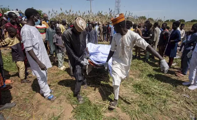 People carry the body of a victim of a tanker explosion ahead of a funeral in Majiya town, Nigeria, Wednesday, Oct. 16, 2024. (AP Photo/Sani Maikatanga)