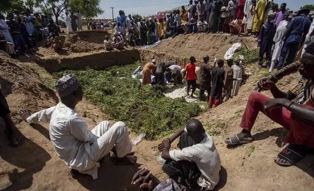 People prepare bodies for burial, following a tanker explosion in Majiya town, Nigeria, Wednesday, Oct. 16, 2024. (AP Photo/Sani Maikatanga)