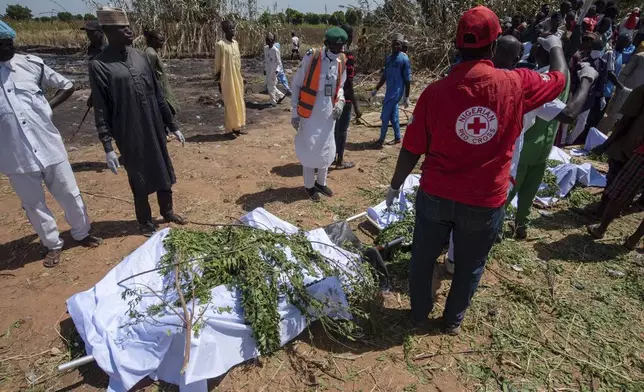 People prepare bodies for burial following a tanker explosion in Majiya town, Nigeria, Wednesday, Oct. 16, 2024. (AP Photo/Sani Maikatanga)