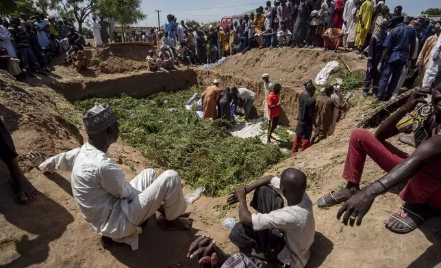 People prepare bodies for burial following a tanker explosion in Majiya town, Nigeria, Wednesday, Oct. 16, 2024. (AP Photo/Sani Maikatanga)