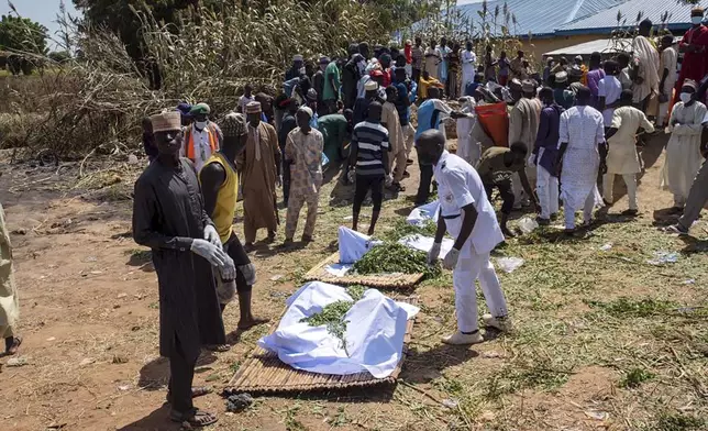 People prepare bodies for funeral following a tanker explosion in Majiya town Nigeria, Wednesday, Oct.16, 2024. ( AP Photo/ Sani Maikatanga)