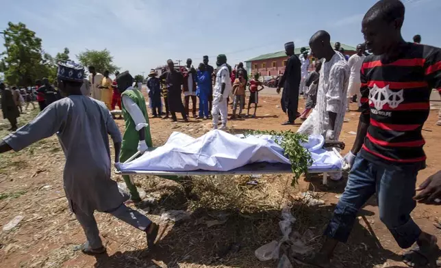 People carry the body of a victim of a tanker explosion for funeral in Majiya town, Nigeria, Wednesday, Oct. 16, 2024. (AP Photo/Sani Maikatanga)