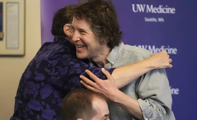 University of Washington president Ana Mari Cauce hugs American biochemist David Baker, 2024 Nobel Prize winner in Chemistry, during news conference at the university on Wednesday, Oct. 9, 2024, in Seattle. (AP Photo/Lindsey Wasson)