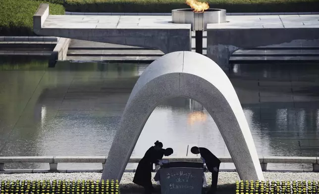 FILE - Kazumi Matsui, right, mayor of Hiroshima bows, at Hiroshima Memorial Cenotaph, at the Hiroshima Peace Memorial Park in Hiroshima, western Japan, Aug. 6, 2015. The Nobel Peace Prize has been awarded to Nihon Hidankyo, a Japanese organization of survivors of the U.S. atomic bombings of Hiroshima and Nagasaki, for its activism against nuclear weapons. (AP Photo/Eugene Hoshiko, File)