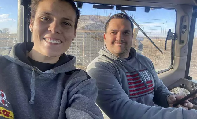 This undated photo provided by Anke van Eeden shows Nicolaas and Anke van Eeden in a tractor on a ranch near Tioga, N.D. Nicolaas van Eeden, 26, died Saturday, Oct. 5, 2024, in connection with a large wildfire burning near Ray, N.D. (Anke van Eeden via AP)