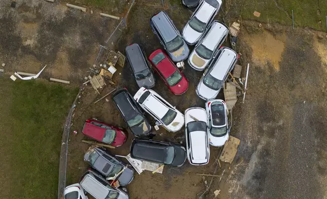 Vehicles and debris that were caught in a flash flood from Hurricane Helene rest on the side of the road near the Swannanoa River, Tuesday, Oct. 1, 2024, in Swannanoa, N.C. (AP Photo/Mike Stewart)