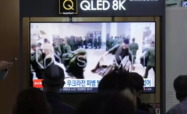 A TV screen shows an image of soldiers believed to be from North Korea stand in line to receive supplies from Russia during a news program at Seoul Railway Station in Seoul, South Korea, Monday, Oct. 21, 2024. (AP Photo/Ahn Young-joon)