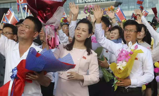 People wave to North Korean women's football team who won the trophy in the FIFA U-20 Women's World Cup held in Colombia, on their arrival at an airport in Pyongyang, North Korea, on Saturday, Sept. 28, 2024. (AP Photo/Jon Chol Jin)