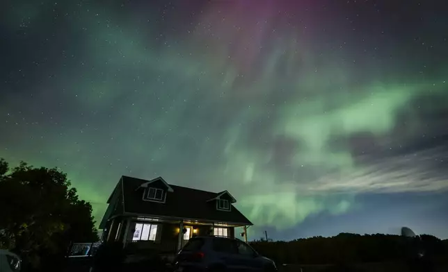 An aurora borealis, also known as the northern lights, is seen over a home near Cremona, Alberta, Monday, Oct. 7, 2024. (Jeff McIntosh/The Canadian Press via AP)