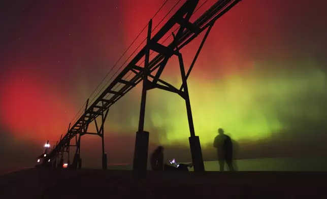 An aurora borealis, also known as the northern lights, lights up the night sky off Lake Michigan and the St. Joseph Lighthouse, Thursday, Oct. 10, 2024, in St. Joseph, Mich. (Don Campbell/The Herald-Palladium via AP)