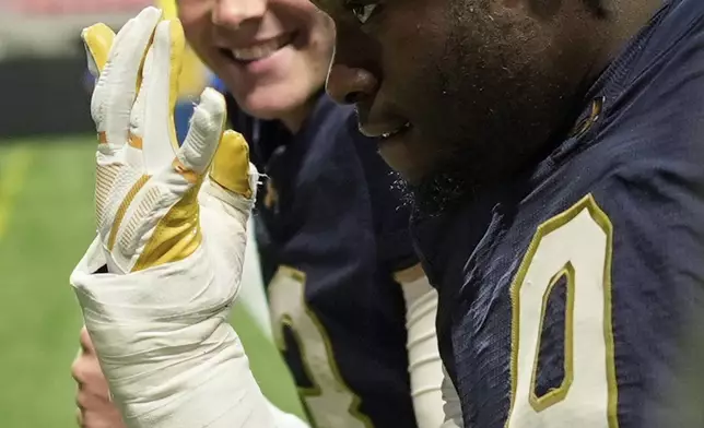 Notre Dame quarterback Riley Leonard, left, and Notre Dame tight end Eli Raridon walk off the field after an NCAA college football game against Georgia Tech, Saturday, Oct. 19, 2024, in Atlanta. (AP Photo/Mike Stewart)