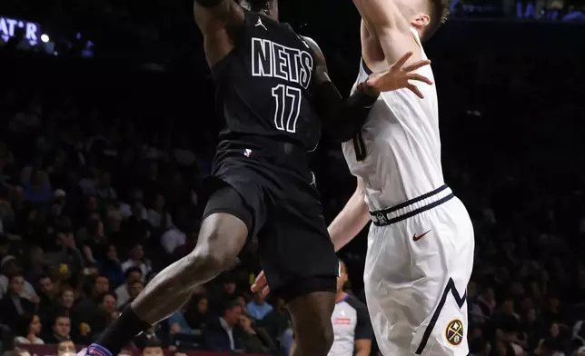 Brooklyn Nets' Dennis Schroder (17), of Germany, goes to the basket against Denver Nuggets' Christian Braun (0) during the first quarter of an NBA basketball game, Tuesday, Oct. 29, 2024, in New York. (AP Photo/Jason DeCrow)