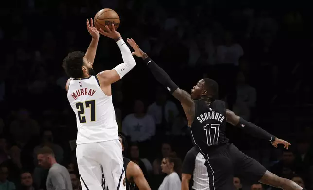 Denver Nuggets' Jamal Murray (27) shoots against Brooklyn Nets' Dennis Schroder (17), of Germany, during the first quarter of an NBA basketball game Tuesday, Oct. 29, 2024, in New York. (AP Photo/Jason DeCrow)