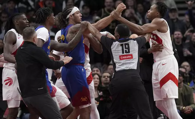 Toronto Raptors forward Scottie Barnes, right, and Denver Nuggets forward Aaron Gordon, fourth from left, get into a pushing match during second-half NBA basketball game action in Toronto, Monday, Oct. 28, 2024. (Nathan Denette/The Canadian Press via AP)