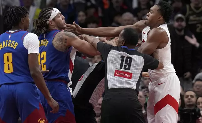 Toronto Raptors forward Scottie Barnes, right, and Denver Nuggets forward Aaron Gordon, second from left, get into a pushing match during second-half NBA basketball game action in Toronto, Monday, Oct. 28, 2024. (Nathan Denette/The Canadian Press via AP)