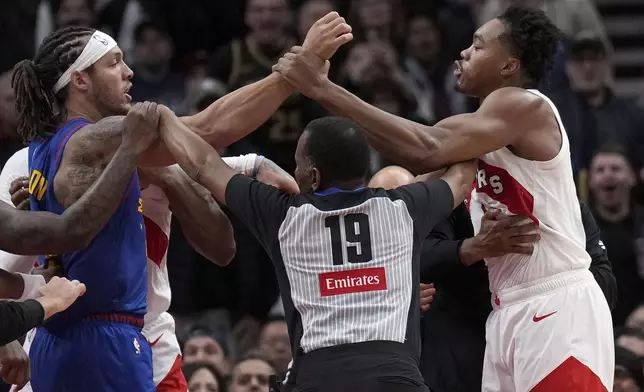 Toronto Raptors forward Scottie Barnes, right, and Denver Nuggets forward Aaron Gordon, left, get into a pushing match during second-half NBA basketball game action in Toronto, Monday, Oct. 28, 2024. (Nathan Denette/The Canadian Press via AP)